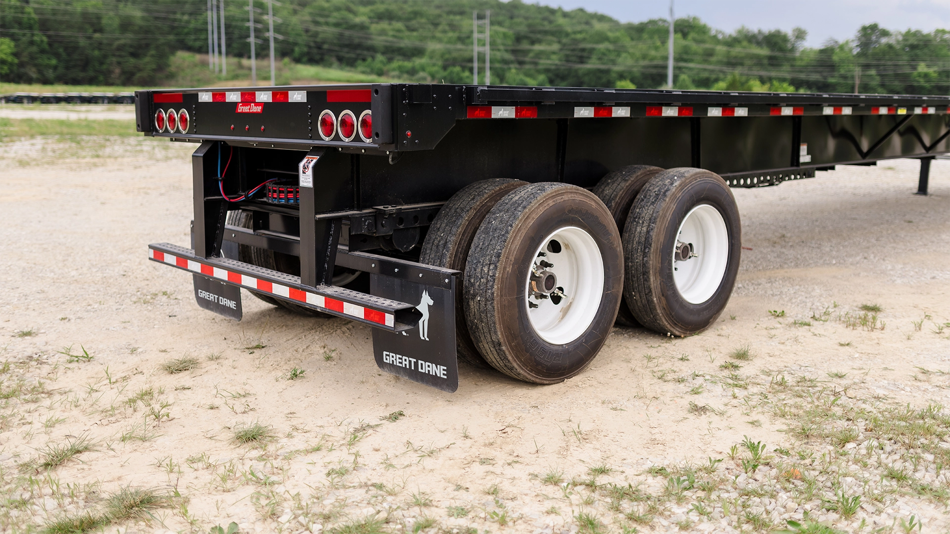Rear view of a Great Dane Freedom Steel flatbed trailer featuring the rear impact guard, lighting system, and heavy-duty steel construction designed to enhance safety and durability.